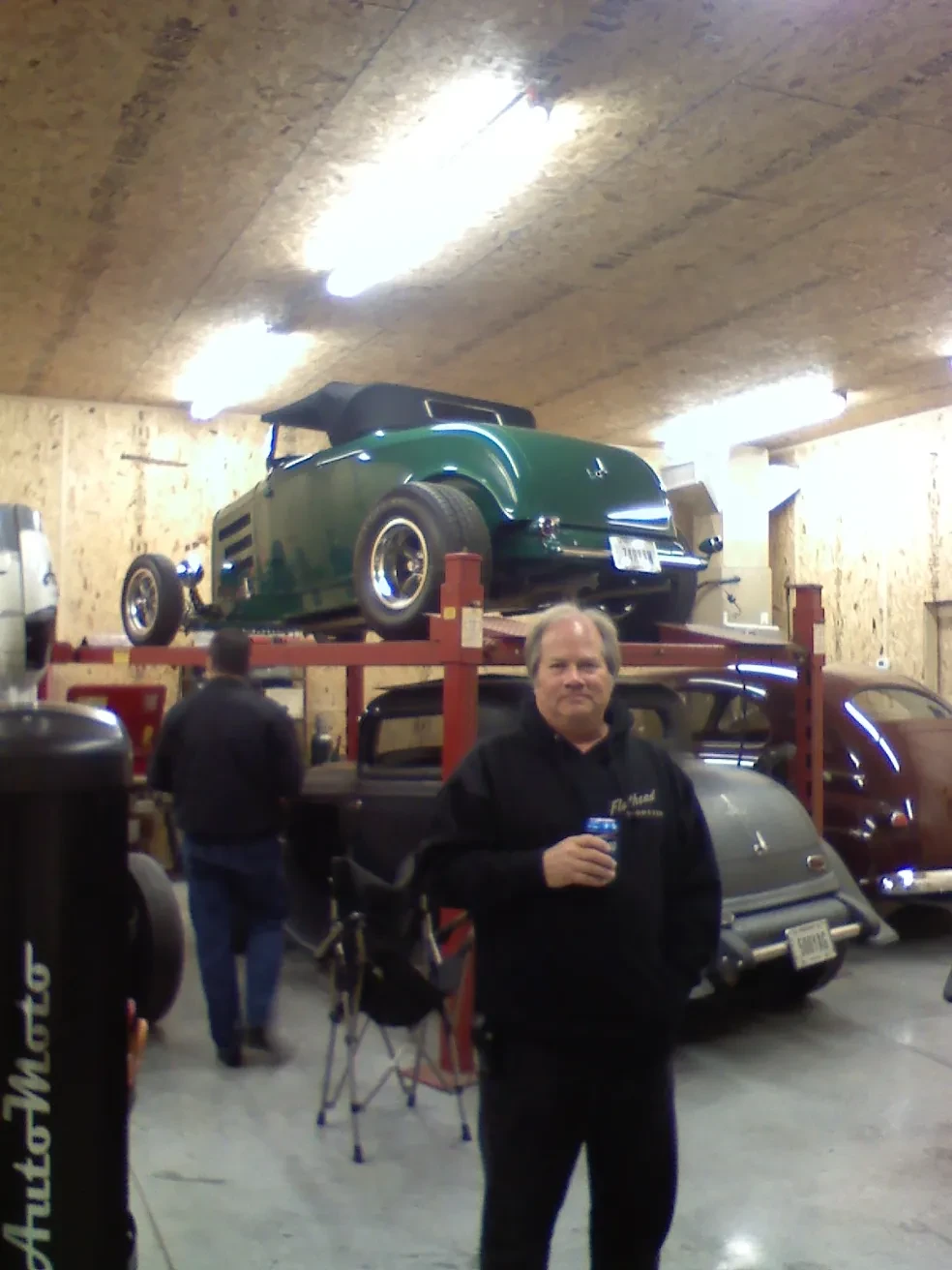 Vintage green convertible on garage lift