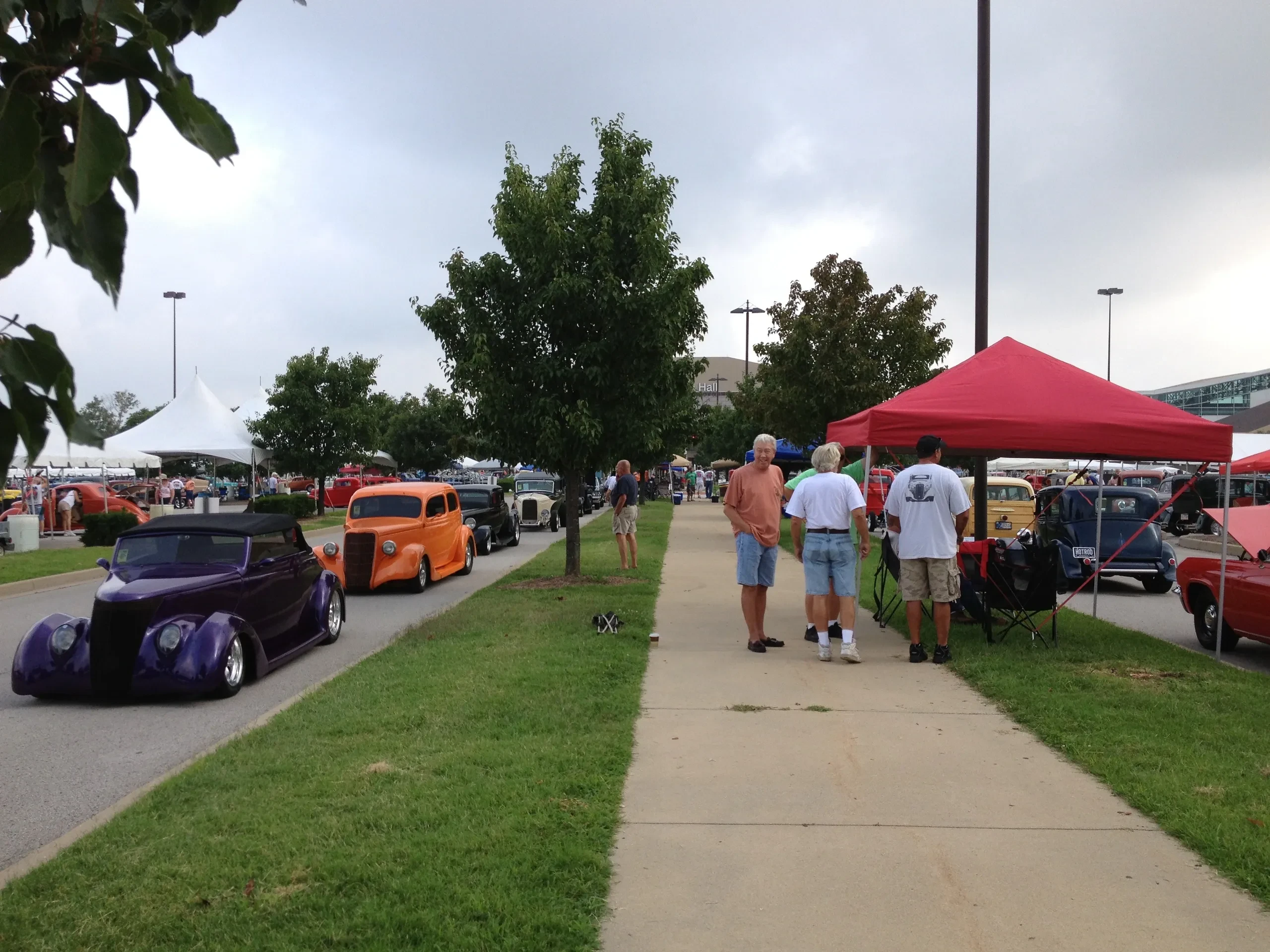 Car show with tents and vintage vehicles