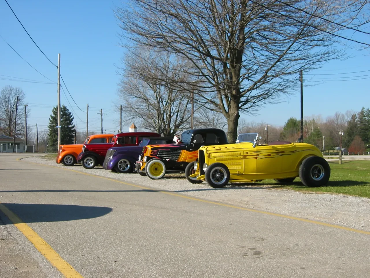 Colorful hot rods lined up on road